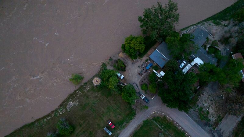 The roaring Yellowstone River is seen from the air sweeping over trees and near homes Tuesday,...
